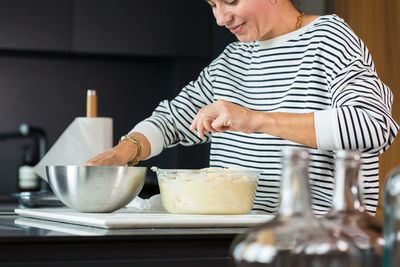 Midsection of woman using mobile phone on table