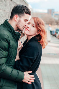Side view of young couple standing outdoors
