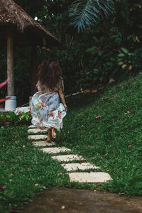 Rear view of girl standing on footpath