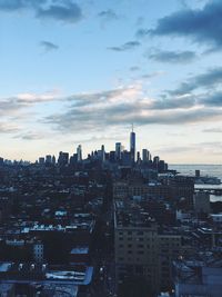 View of cityscape against cloudy sky