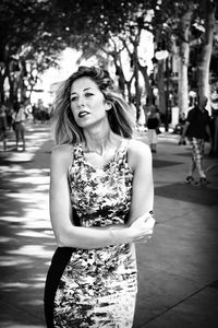 Mid adult woman with arms crossed standing in park