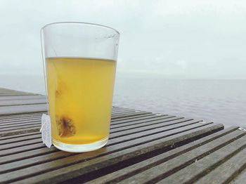 Close-up of drink on table by sea