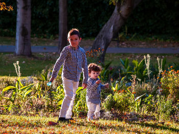 Portrait of boy with brother playing in park during autumn