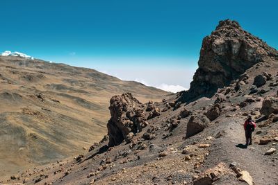 A hiker  in the scenic mountain landscapes above the clouds at mount kilimanjaro, tanzania