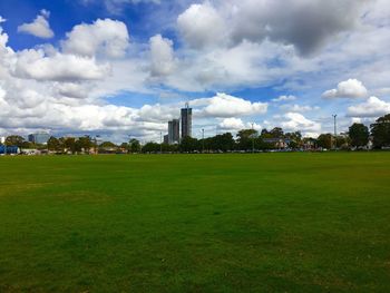 Scenic view of grassy field against cloudy sky