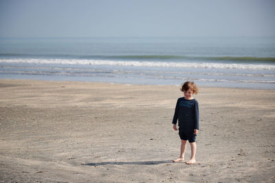 Rear view of boy standing on beach