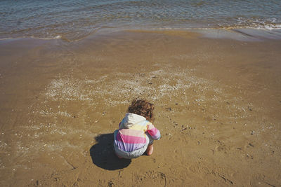 Rear view of girl playing in sea