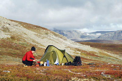 Woman near tent in mountains