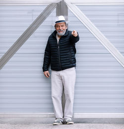 A man standing near his automatic gate, coming home from work, the security and safety of his home