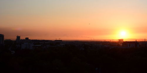 High angle view of silhouette buildings against sky during sunset