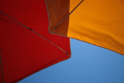 Low angle view of shade umbrellas against clear sky