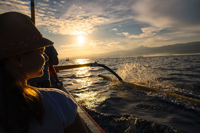 Rear view of woman on a nautical vessel during sunset