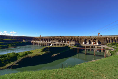 View of bridge over canal against clear blue sky