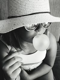 Close-up portrait of cute girl holding hat