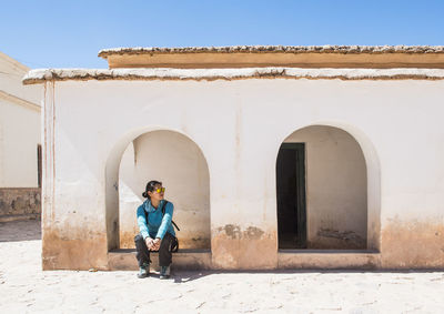 Woman waiting in archway at small village in purmamarca / argentina