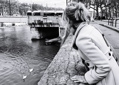 Rear view of woman with umbrella in river