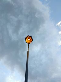 Low angle view of illuminated street light against sky