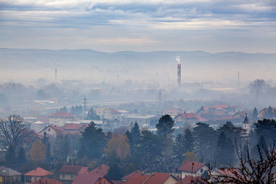 Smoke emitting from chimney against sky