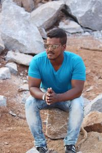 Young man sitting on rock