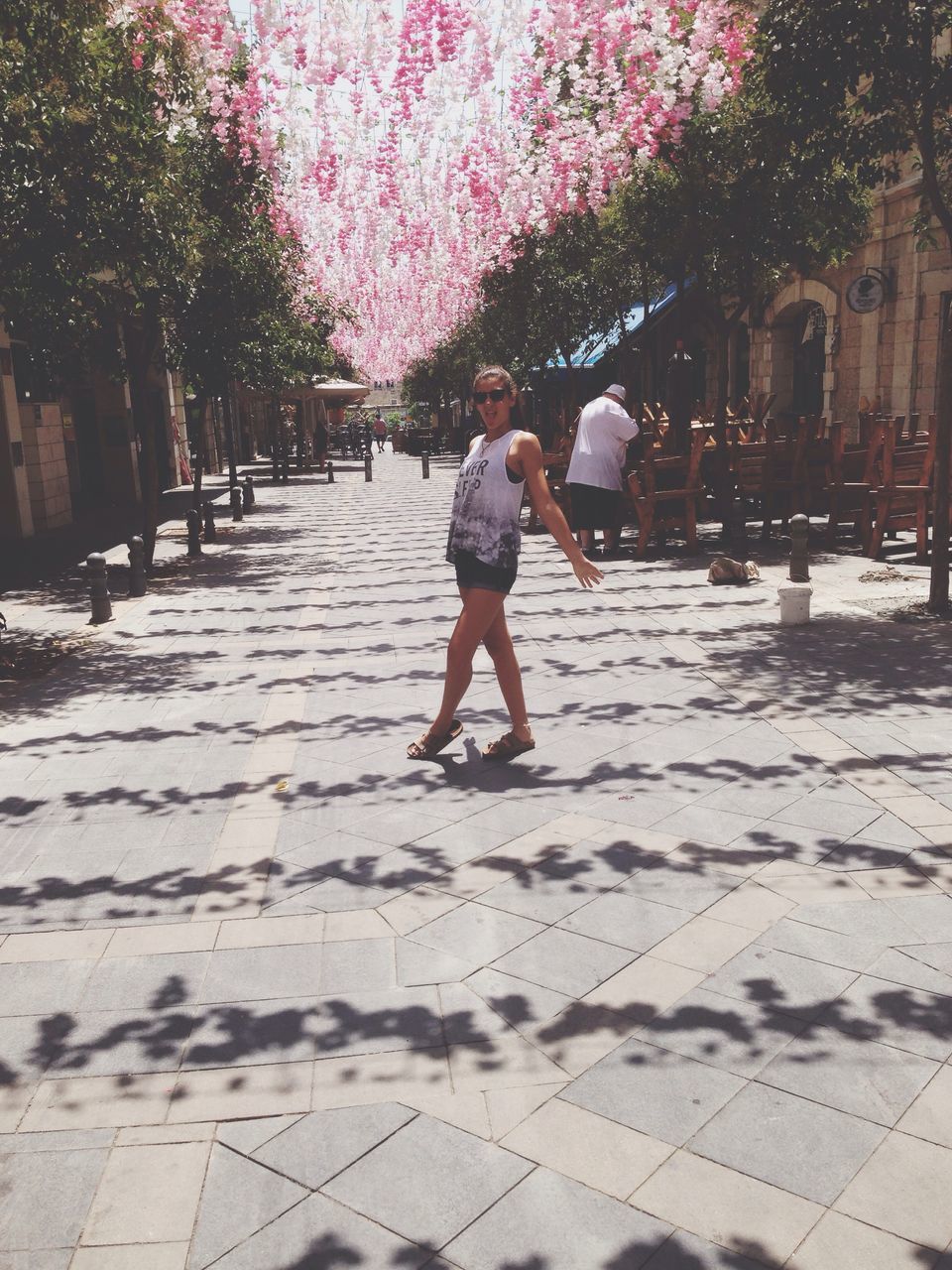 lifestyles, leisure activity, tree, footpath, casual clothing, outdoors, the way forward, day, city life, city, pavement, pink color, walkway, nature