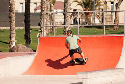 Man riding skateboard in urban street skatepark. casual guy wearing shorts and t-shirt.