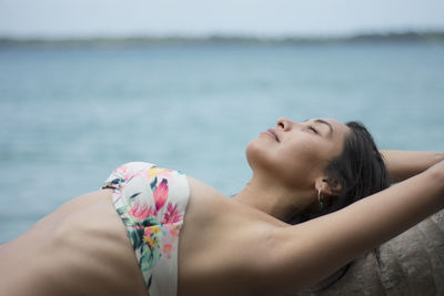 Midsection of woman lying on beach
