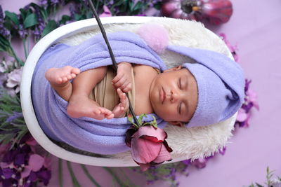 New born baby with a rose in his hand