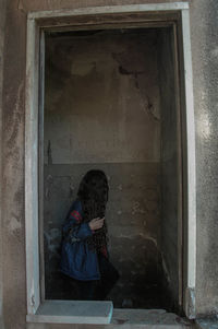 Woman sitting in abandoned room