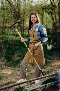 Portrait of young woman standing on field