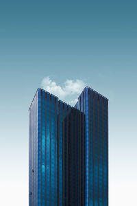 Low angle view of skyscraper against blue sky