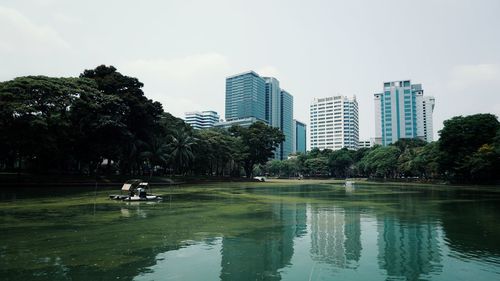 Scenic view of lake by buildings against sky