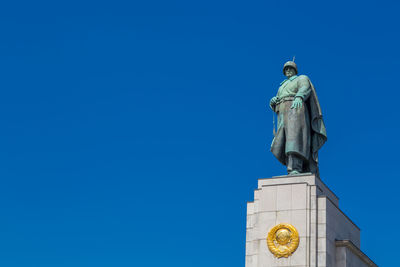 Low angle view of statue against blue sky