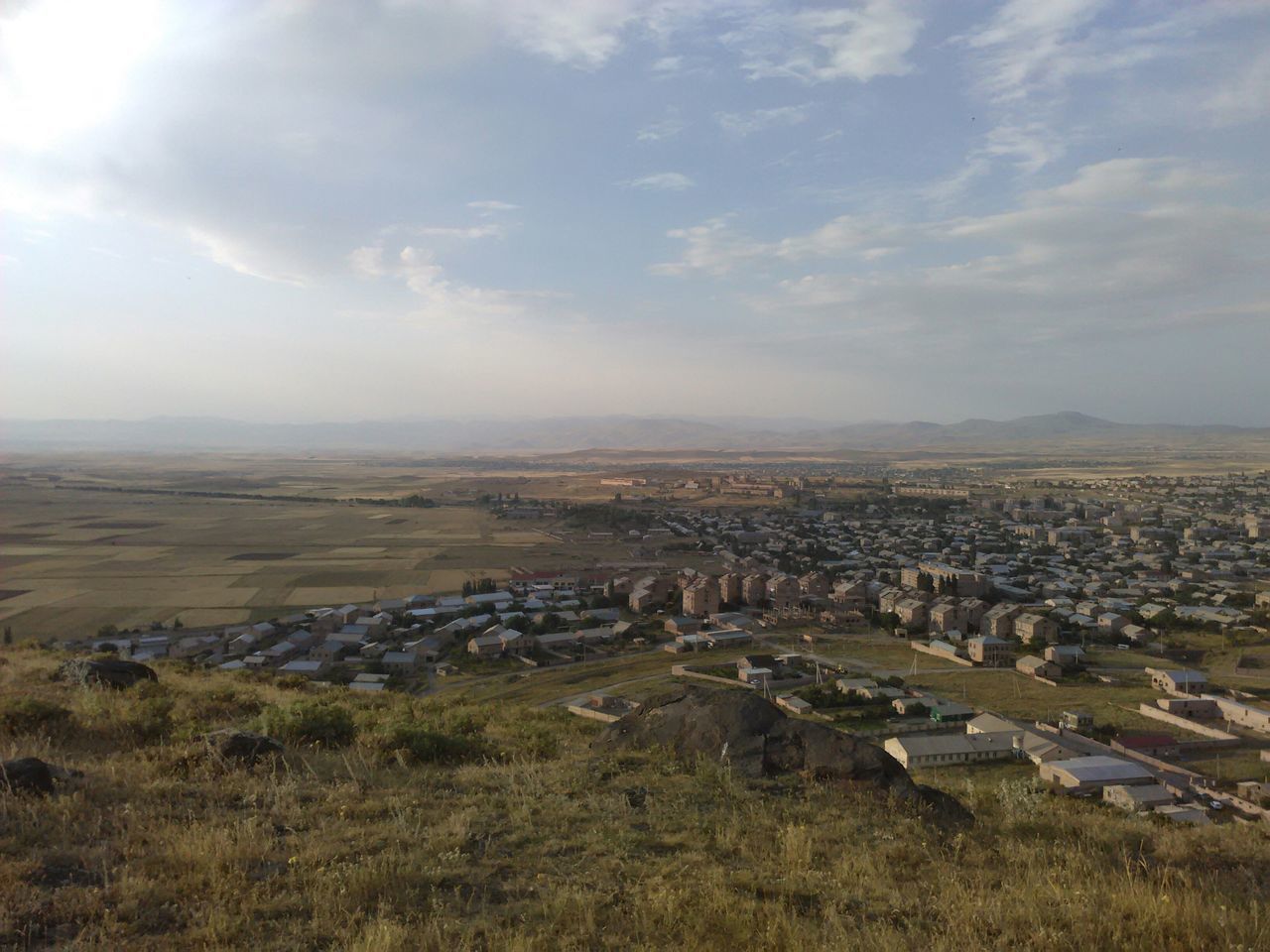 sky, building exterior, cityscape, landscape, architecture, built structure, city, high angle view, crowded, cloud - sky, aerial view, residential district, horizon over land, cloud, field, nature, outdoors, day, agriculture, residential structure