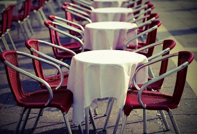 Empty chairs and tables at sidewalk caf