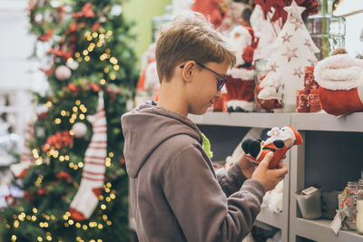 Side view of man holding christmas tree