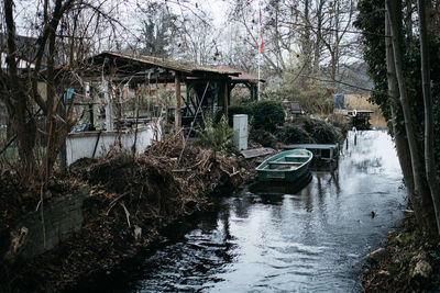 Bridge over river amidst bare trees and buildings