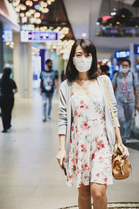 Full length of woman standing against wall