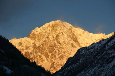 Low angle view of snowcapped mountains against sky