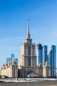 Buildings in city against blue sky