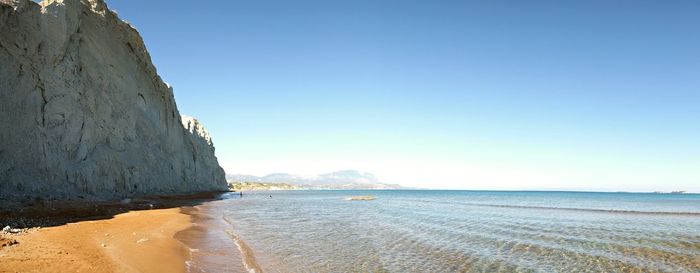 Scenic view of beach against clear blue sky