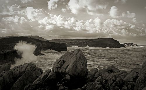 Scenic view of rocks in sea against sky