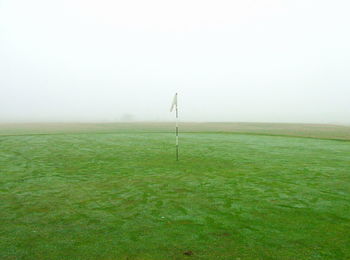 Scenic view of golf course against sky