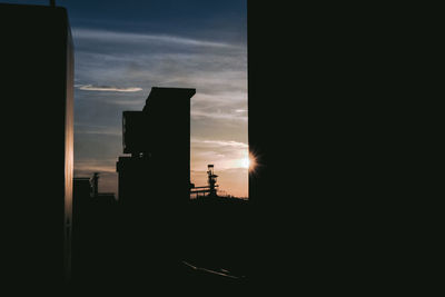 Silhouette buildings against sky during sunset