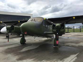 Airplane on airport runway against sky