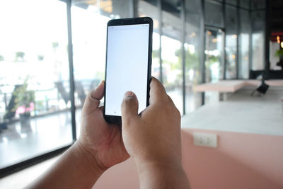 Midsection of man using mobile phone