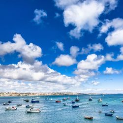 Boats moored on sea against blue sky