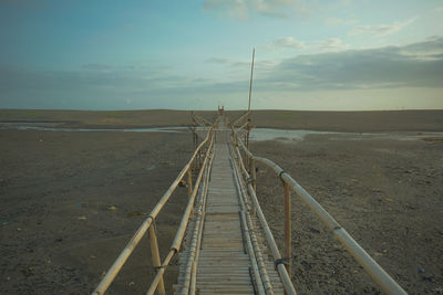 Railroad tracks on land against sky