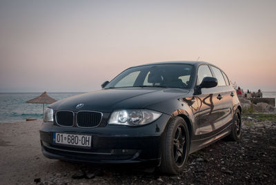 Vintage car on beach against clear sky