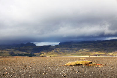 Scenic view of mountain road against cloudy sky