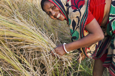 Midsection of man holding plants on field